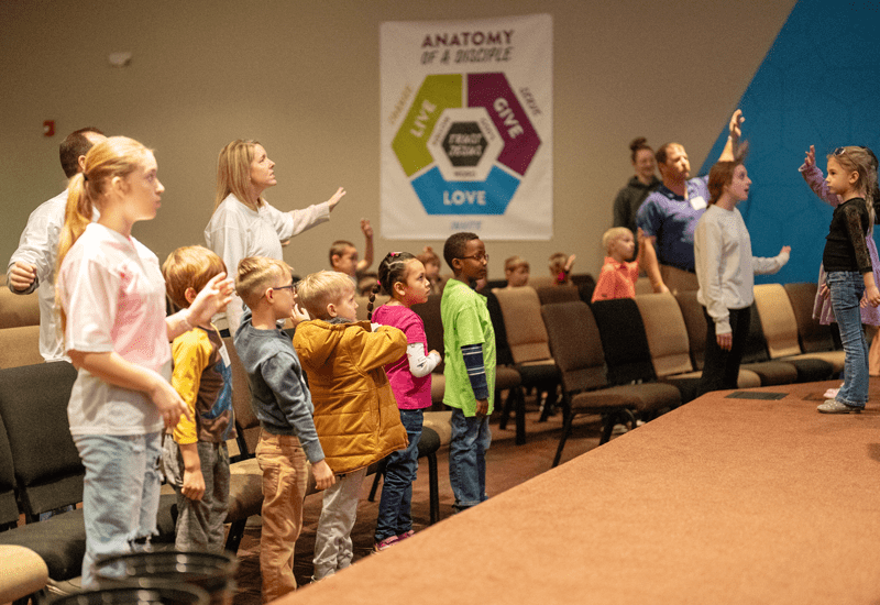 group of kids and adults worshipping during children's church