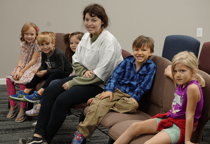 leader sitting with a group of kids at church